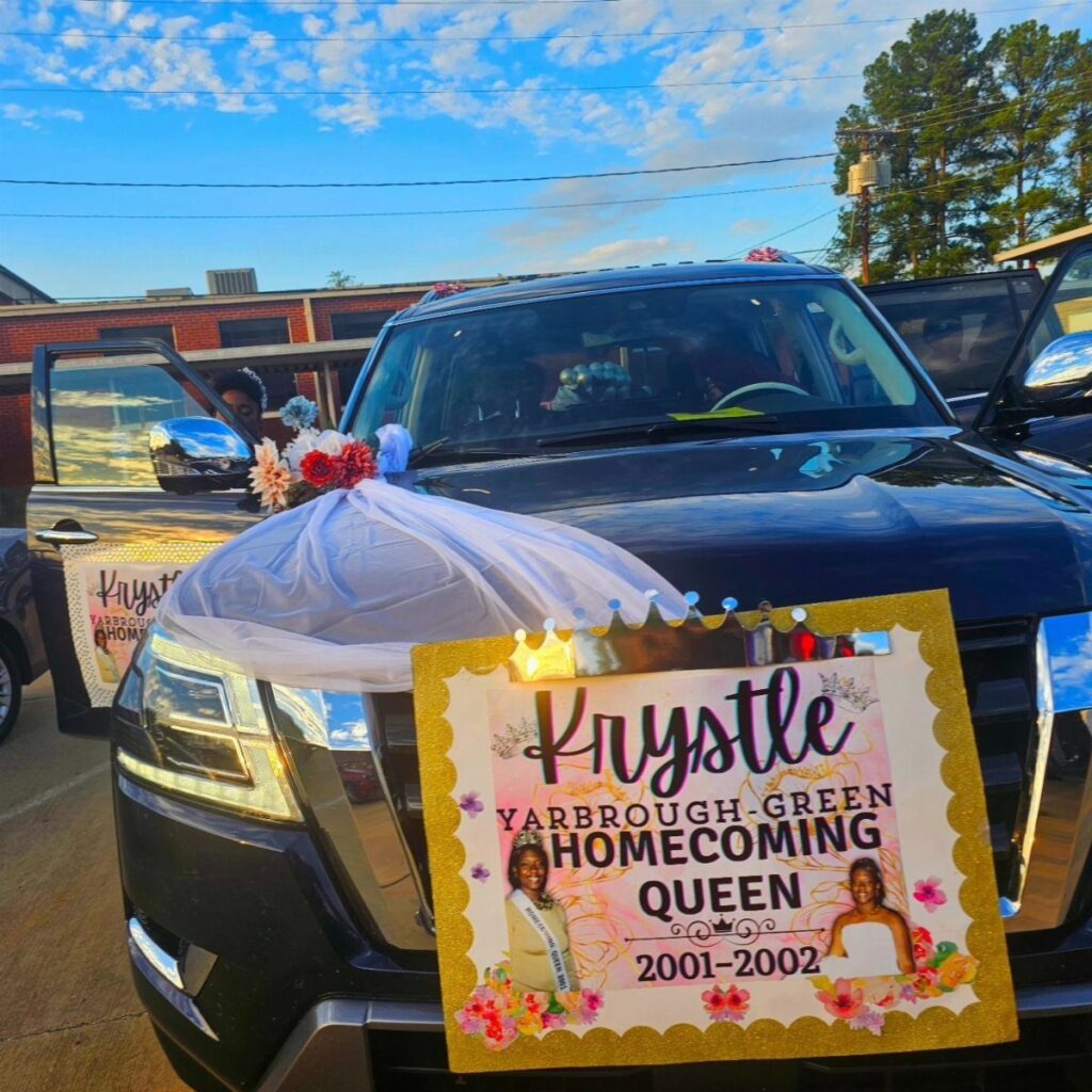 Homecoming Queen campaign poster attached to the front of a decorated blue SUV.