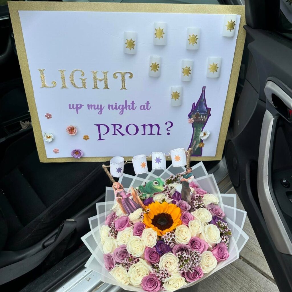 Prom proposal poster with candles and a large bouquet of colorful roses.