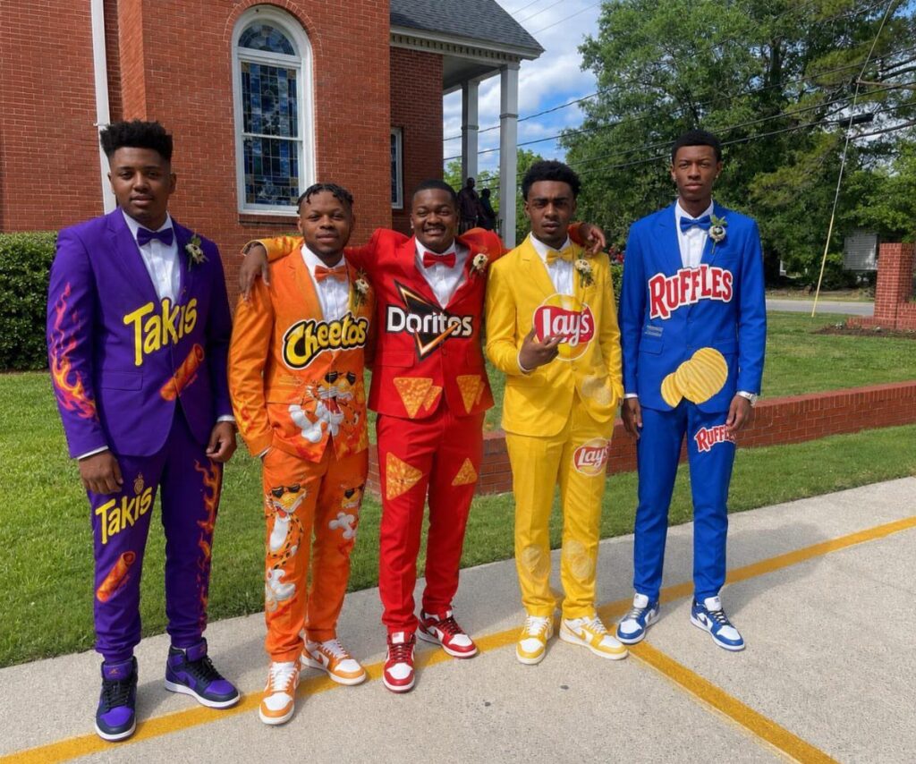 Five young men posing in colorful suits themed after popular snack chip brands.