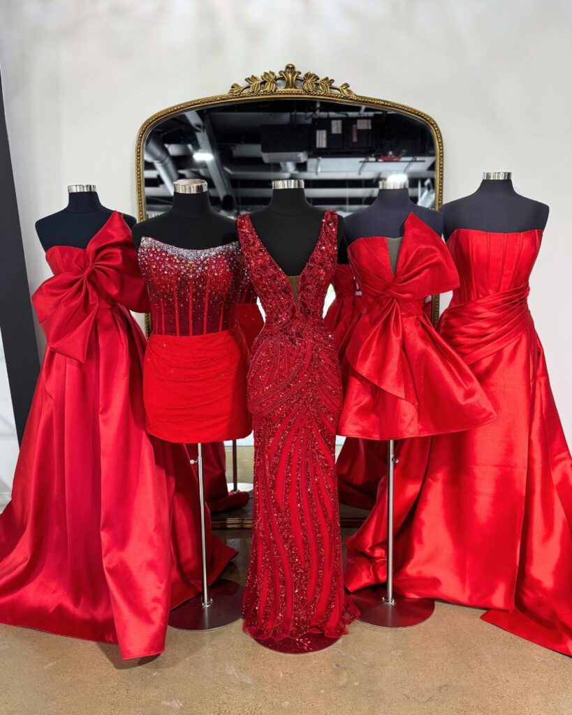 Red formal dresses on mannequins, including long gowns and a short cocktail dress.