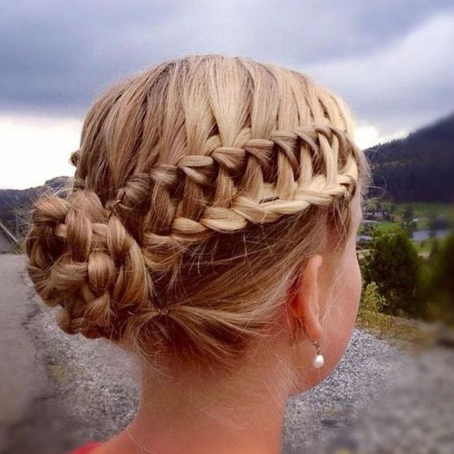 Blonde hair styled in a ladder braid wrapping into a braided bun.