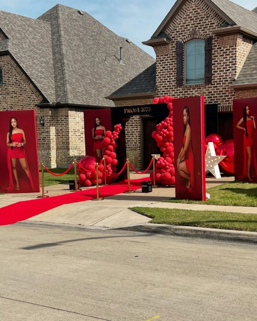Red carpet prom send off setup with red balloons and photo panels