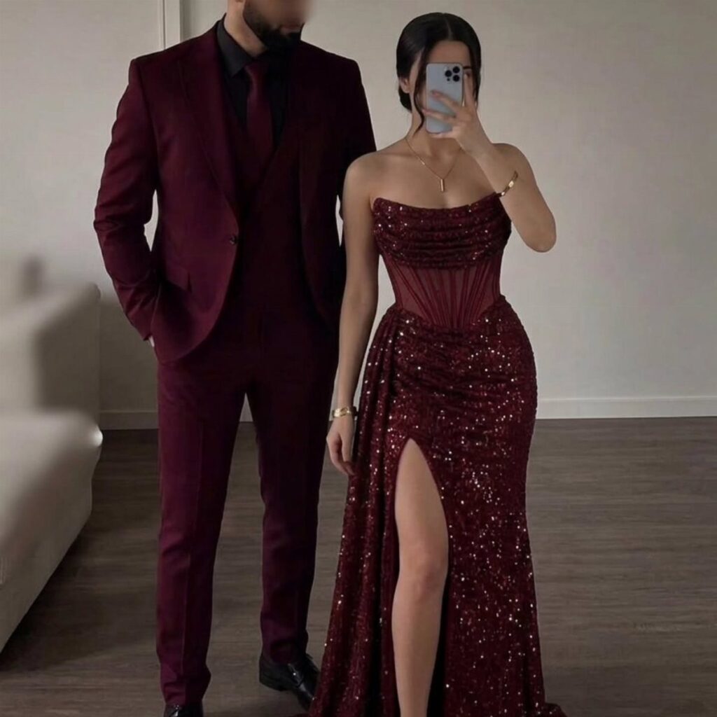 Man in a dark red suit and woman in a matching sequined gown.